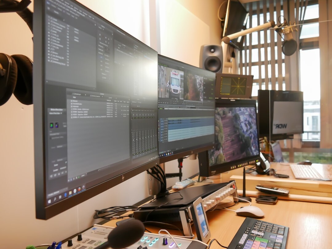 Video editing desk with monitors showing a multi-camera timeline and audio waveforms